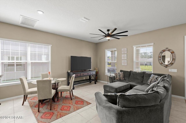 tiled living room with a textured ceiling and ceiling fan