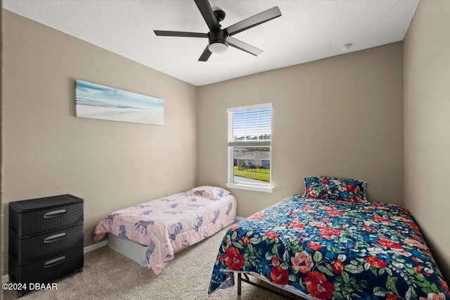 bedroom with a textured ceiling, ceiling fan, and carpet floors