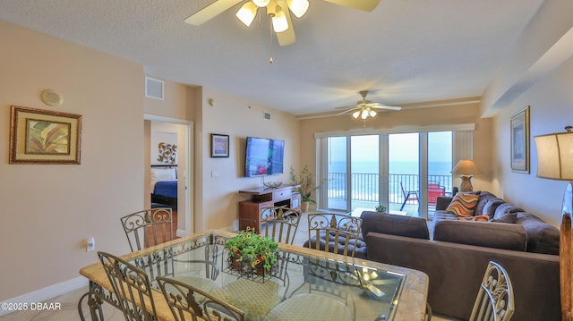 dining area featuring a ceiling fan, a textured ceiling, baseboards, and visible vents