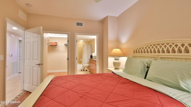 unfurnished bedroom featuring light tile patterned flooring, visible vents, and a walk in closet
