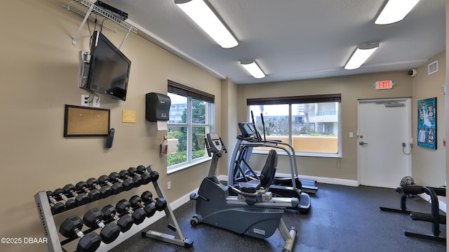 exercise room with baseboards and visible vents