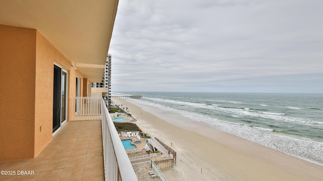 balcony featuring a beach view and a water view