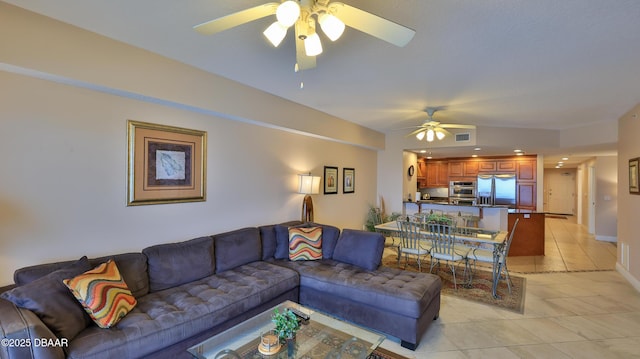 living area featuring baseboards, ceiling fan, visible vents, and light tile patterned floors