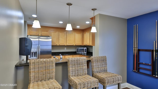 kitchen with a kitchen breakfast bar, recessed lighting, stainless steel appliances, baseboards, and pendant lighting