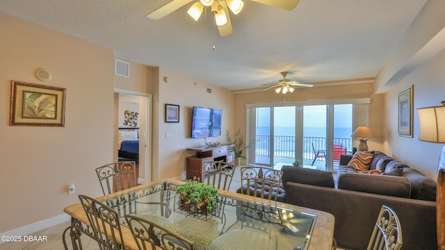 dining area featuring a textured ceiling, visible vents, baseboards, ceiling fan, and tile patterned flooring