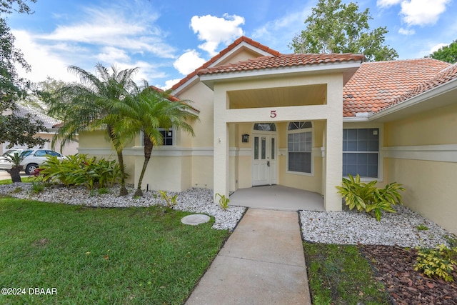 property entrance with a lawn