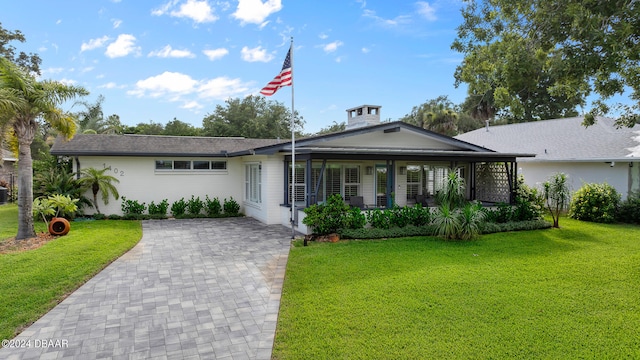 ranch-style house featuring a front lawn and covered porch