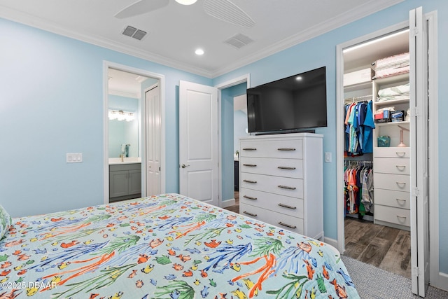 bedroom with hardwood / wood-style flooring, ceiling fan, ensuite bathroom, ornamental molding, and a closet