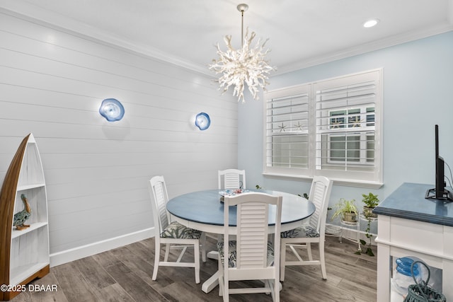 dining space with an inviting chandelier, crown molding, and dark wood-type flooring