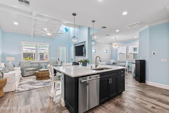 kitchen with decorative light fixtures, dishwasher, sink, a center island with sink, and light wood-type flooring