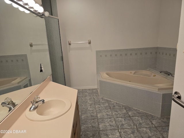 bathroom featuring vanity, tile patterned floors, and tiled tub