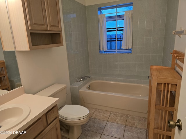 full bathroom featuring tile patterned flooring, vanity, toilet, and tiled shower / bath