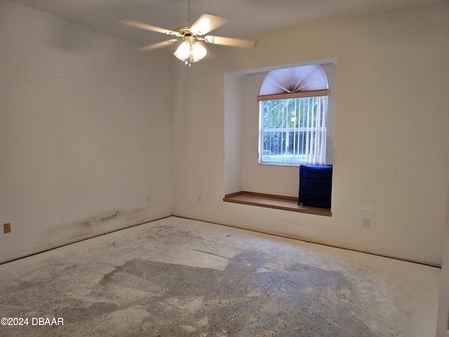 empty room with ceiling fan and concrete floors