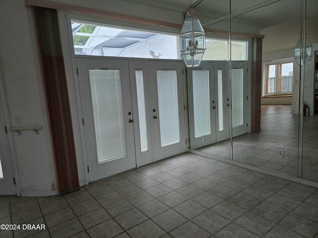 doorway with light tile patterned flooring and a healthy amount of sunlight