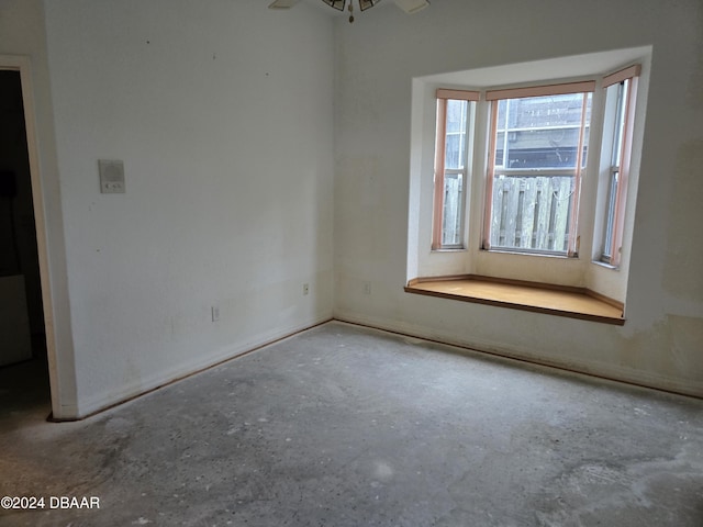 empty room featuring ceiling fan and concrete flooring