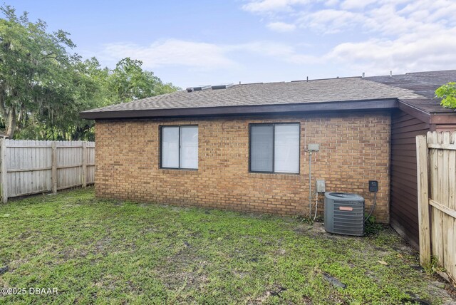 1518 Franklin Cir, Holly Hill, FL 32117 - view of side of property with roof with shingles, central air condition unit, and brick siding