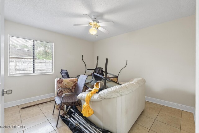1518 Franklin Cir, Holly Hill, FL 32117 - living area featuring light tile patterned floors, baseboards, a ceiling fan, and a textured ceiling