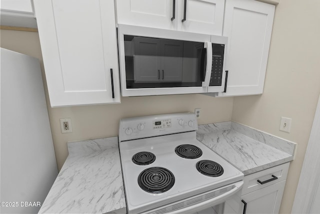 1518 Franklin Cir, Holly Hill, FL 32117 - kitchen with white electric range oven, stainless steel microwave, white cabinets, and light stone counters