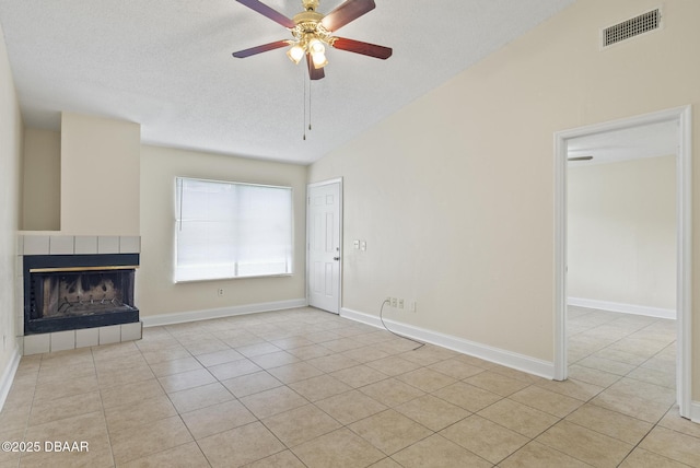 1518 Franklin Cir, Holly Hill, FL 32117 - unfurnished living room with light tile patterned floors, ceiling fan, a fireplace, a textured ceiling, and vaulted ceiling