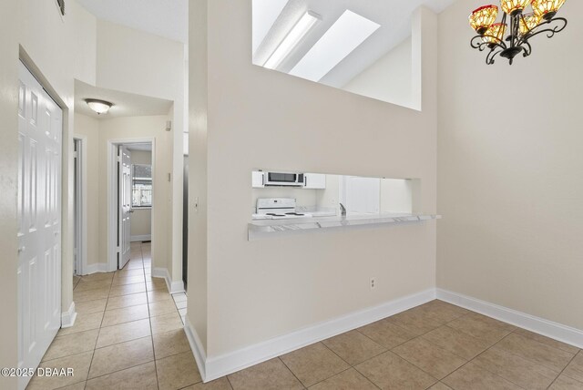 1518 Franklin Cir, Holly Hill, FL 32117 - hallway featuring high vaulted ceiling, light tile patterned flooring, a skylight, a chandelier, and baseboards