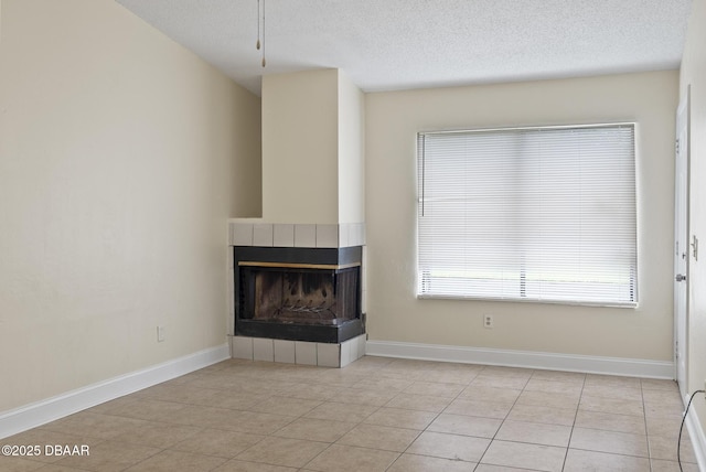 1518 Franklin Cir, Holly Hill, FL 32117 - unfurnished living room with a multi sided fireplace, light tile patterned floors, a textured ceiling, and baseboards