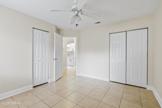 1518 Franklin Cir, Holly Hill, FL 32117 - unfurnished bedroom with light tile patterned floors, a textured ceiling, ceiling fan, and baseboards