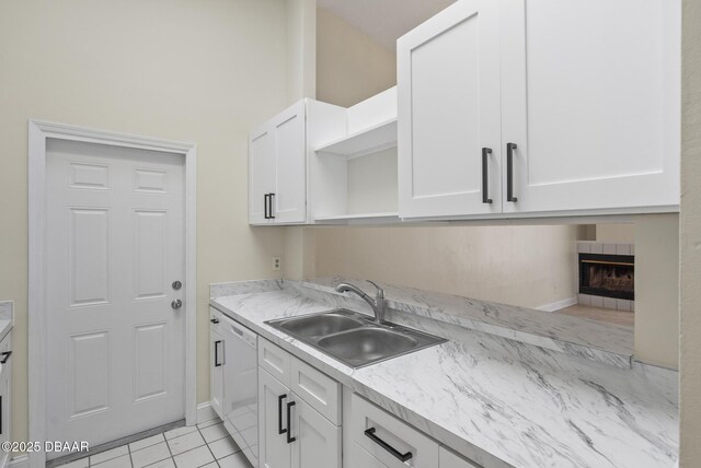 1518 Franklin Cir, Holly Hill, FL 32117 - kitchen featuring a sink, open shelves, white dishwasher, white cabinets, and a tile fireplace