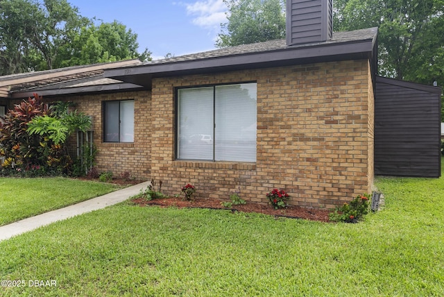 1518 Franklin Cir, Holly Hill, FL 32117 - view of property exterior with brick siding, a lawn, and a chimney