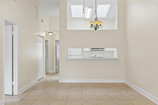 1518 Franklin Cir, Holly Hill, FL 32117 - unfurnished living room with a skylight, a chandelier, tile patterned floors, baseboards, and a high ceiling
