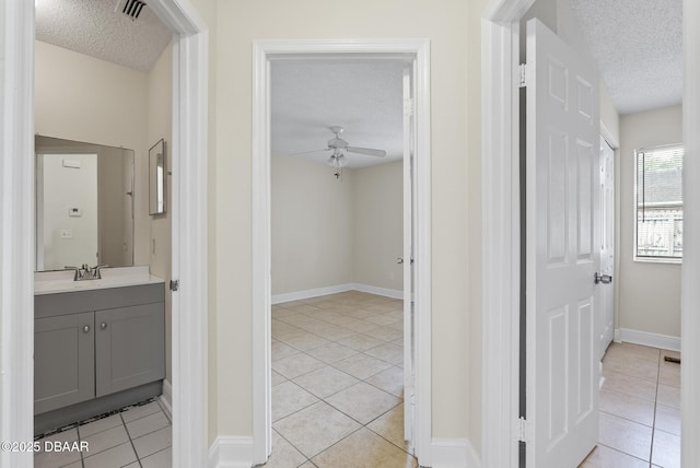 1518 Franklin Cir, Holly Hill, FL 32117 - hallway with a textured ceiling, light tile patterned flooring, a sink, and baseboards