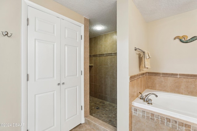 bathroom with tile patterned floors, a textured ceiling, and independent shower and bath