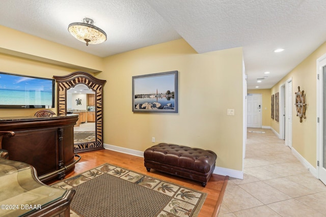 interior space with light tile patterned floors and a textured ceiling