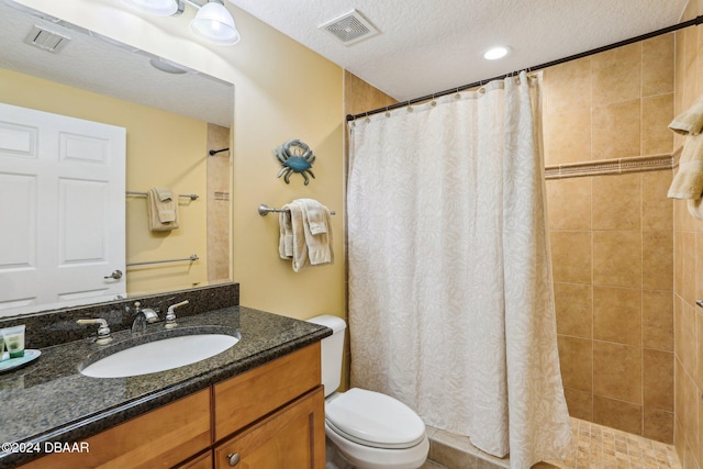 bathroom featuring vanity, curtained shower, toilet, and a textured ceiling