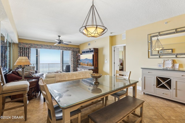 tiled dining space featuring ceiling fan and a textured ceiling