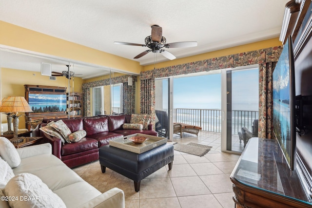 tiled living room with ceiling fan and a textured ceiling