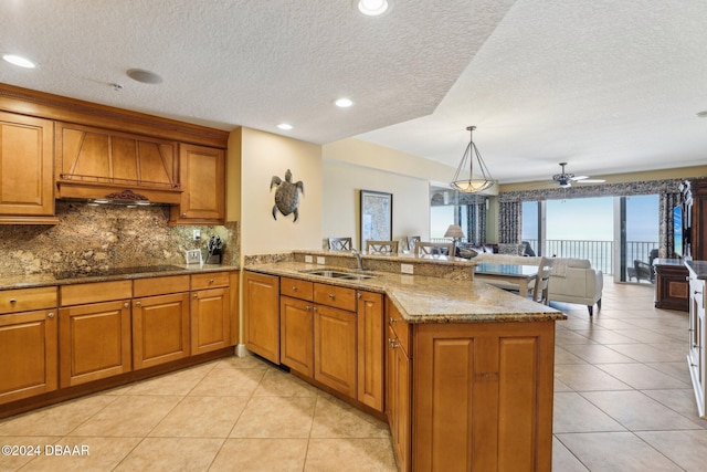 kitchen featuring ceiling fan, sink, kitchen peninsula, decorative light fixtures, and black electric cooktop