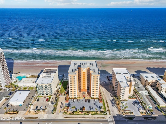 birds eye view of property featuring a water view and a beach view