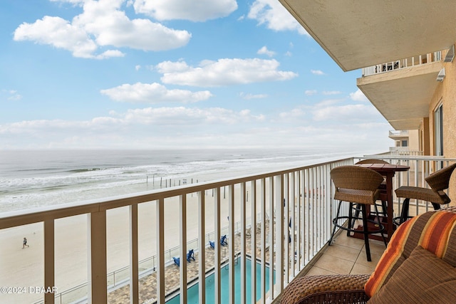 balcony featuring a water view and a beach view