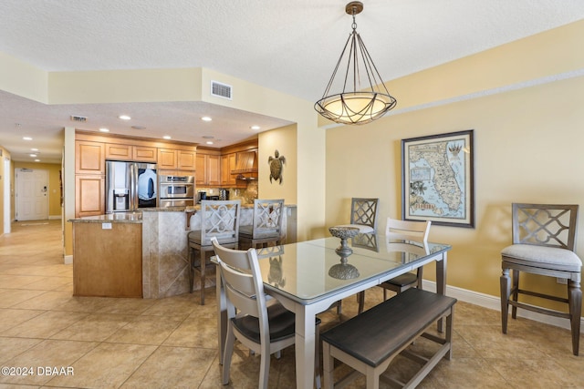 dining space with light tile patterned flooring and a textured ceiling