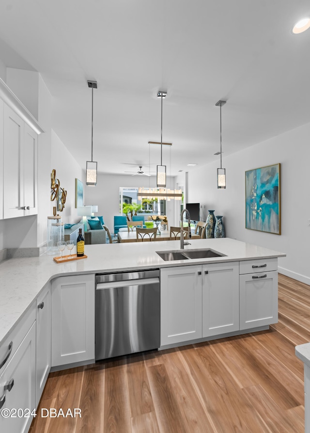 kitchen featuring dishwasher, kitchen peninsula, white cabinets, sink, and light wood-type flooring