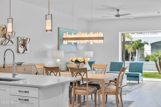 dining space with light hardwood / wood-style floors, sink, and ceiling fan