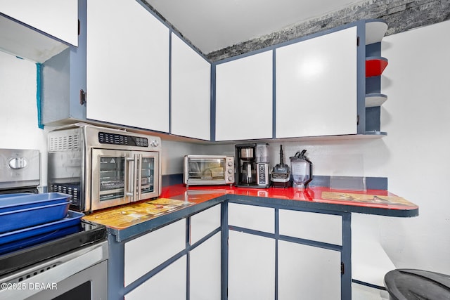 600 Holmes Ave, Daytona Beach, FL 32114 - kitchen featuring dark countertops, white cabinets, stainless steel electric range oven, and open shelves