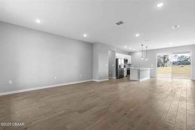 23 Weymouth Ln, Palm Coast, FL 32164 - unfurnished living room with wood finished floors and recessed lighting