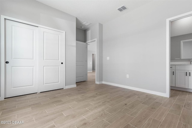 23 Weymouth Ln, Palm Coast, FL 32164 - unfurnished bedroom with light wood-style floors, a closet, and connected bathroom
