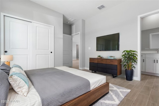23 Weymouth Ln, Palm Coast, FL 32164 - bedroom with a closet, wood tiled floors, and ensuite bath
