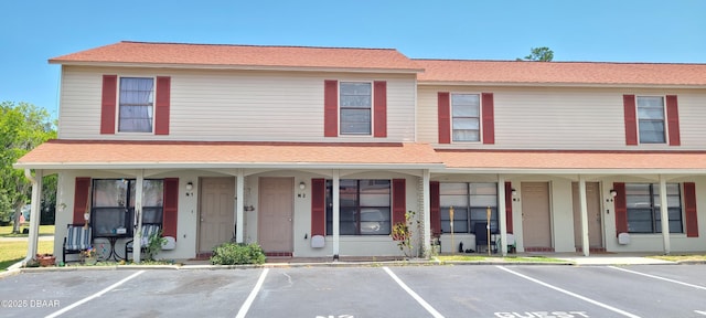 townhome / multi-family property with covered porch and uncovered parking