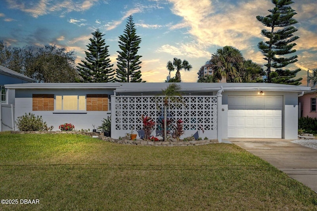 view of front of property featuring an attached garage, driveway, and a front lawn