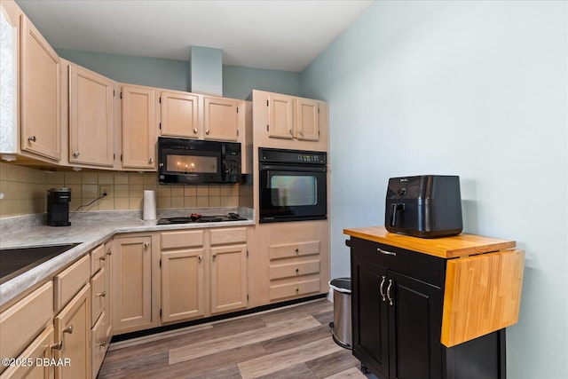 kitchen with black appliances, tasteful backsplash, and light brown cabinets