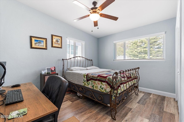 bedroom with a ceiling fan, baseboards, and wood finished floors