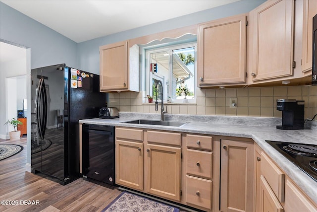 kitchen featuring wine cooler, light brown cabinets, a sink, light countertops, and black appliances